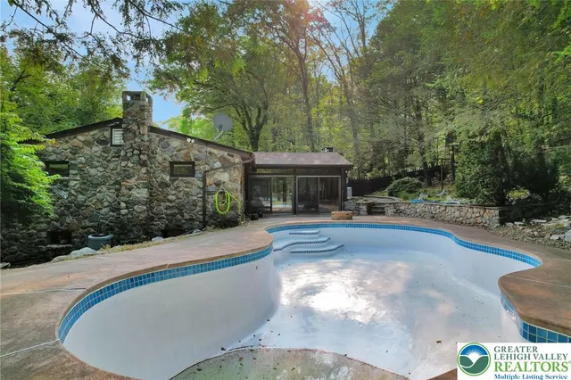 a view of a house with pool and trees around