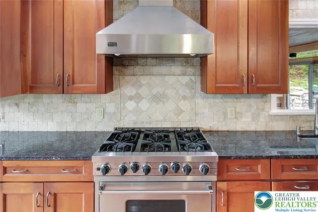 a kitchen with granite countertop a stove a sink and a granite counter tops