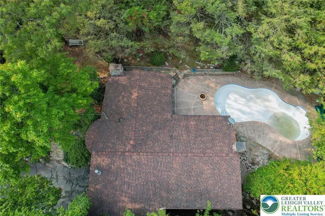 an aerial view of a house with a yard and a large tree