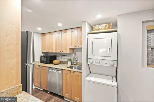 a kitchen with granite countertop cabinets stainless steel appliances and wooden floor