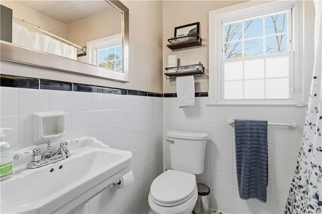 a bathroom with a sink a toilet and a mirror