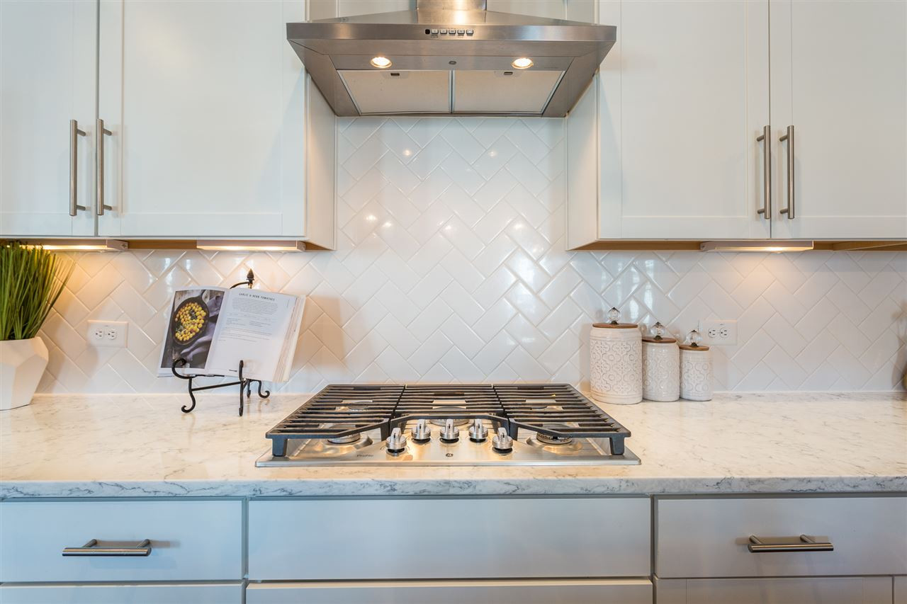 5410 Beckom Street Raleigh, NC 27616 - Photo 4 of 30 Custom tile backsplash. This home was designed to feel light and bright with high end finishes. Kitchen