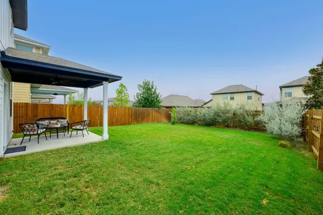 a view of a chair and table in backyard of the house