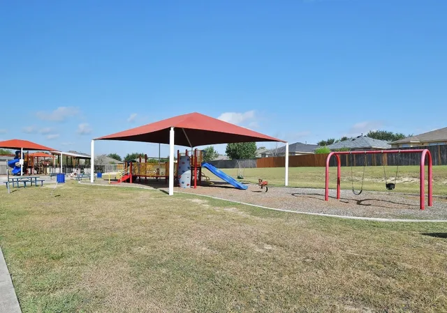 a view of a patio with a table and chairs under an umbrella