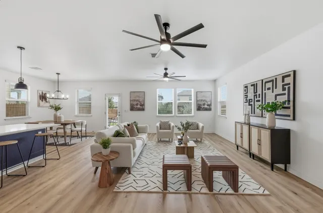 a living room with furniture a window and a ceiling fan
