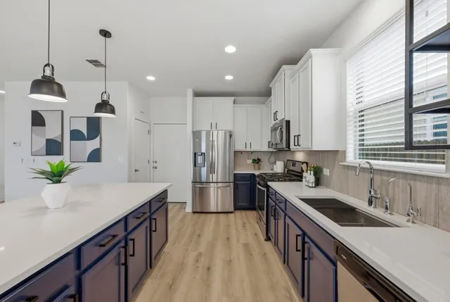 a kitchen with a sink a counter top space stainless steel appliances and a window