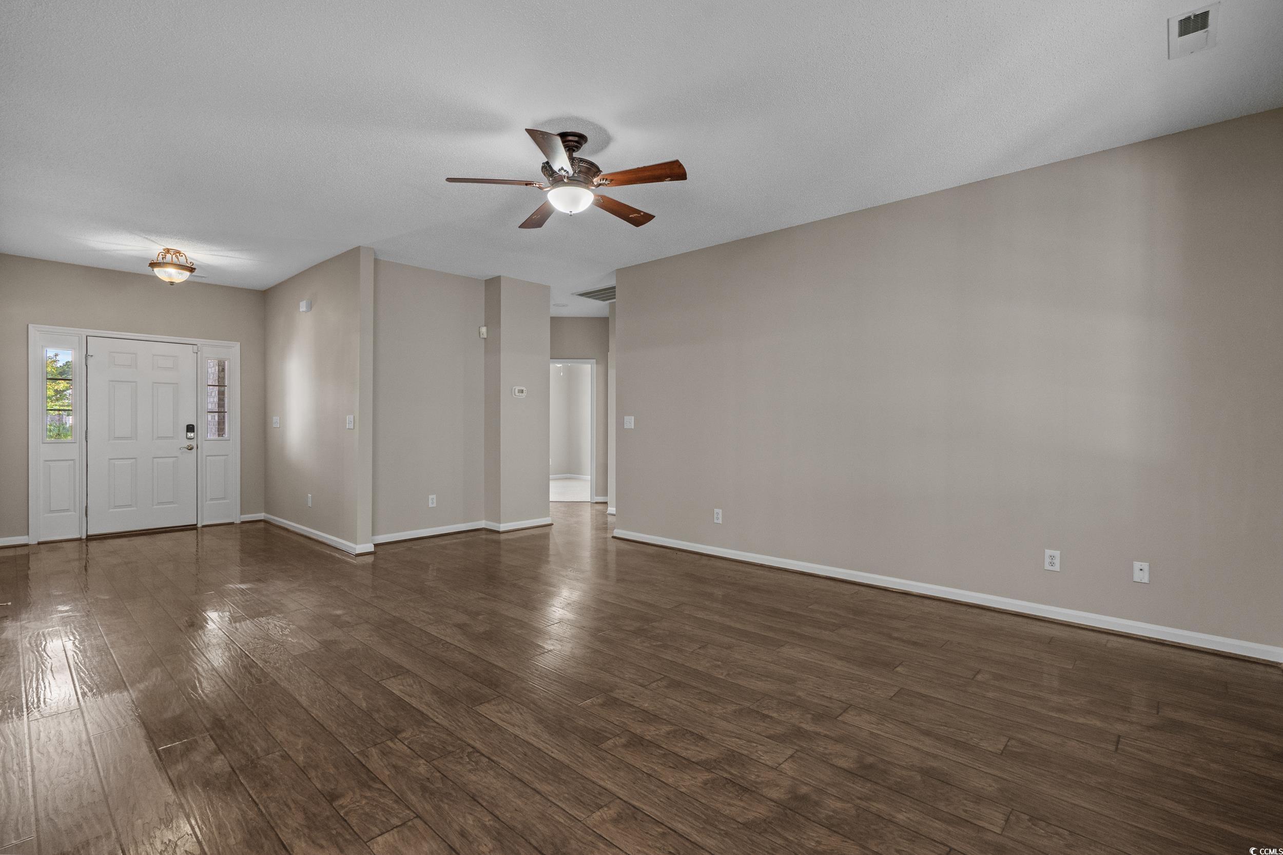 4191 Friendfield Trace Little River, SC 29566 - Photo 8 of 40 Unfurnished living room with dark wood-style floors and a ceiling fan