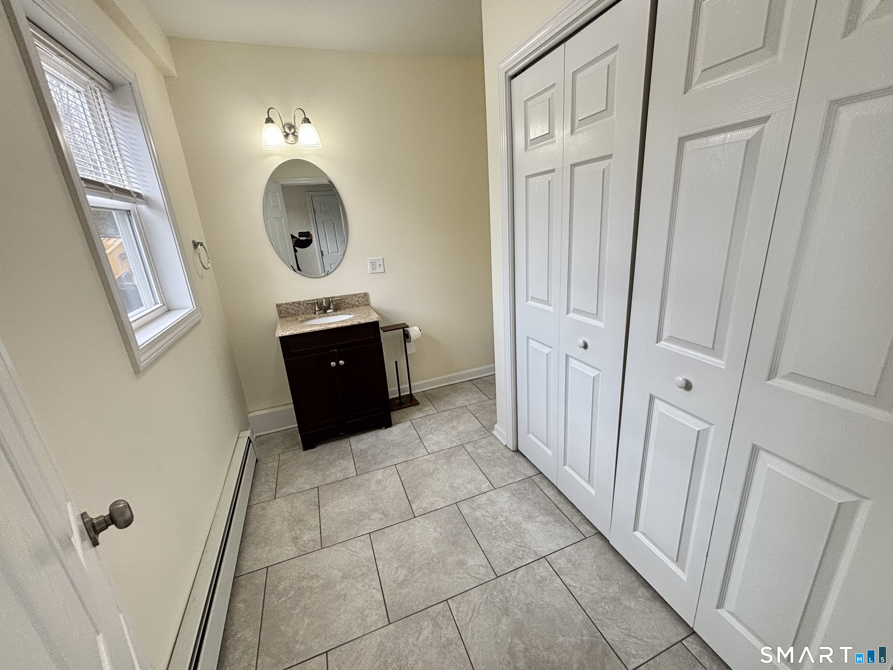 61 Scotland Avenue, Unit NORTH Madison, CT 06443 - Photo 11 of 19 a living room with a sink and a mirror