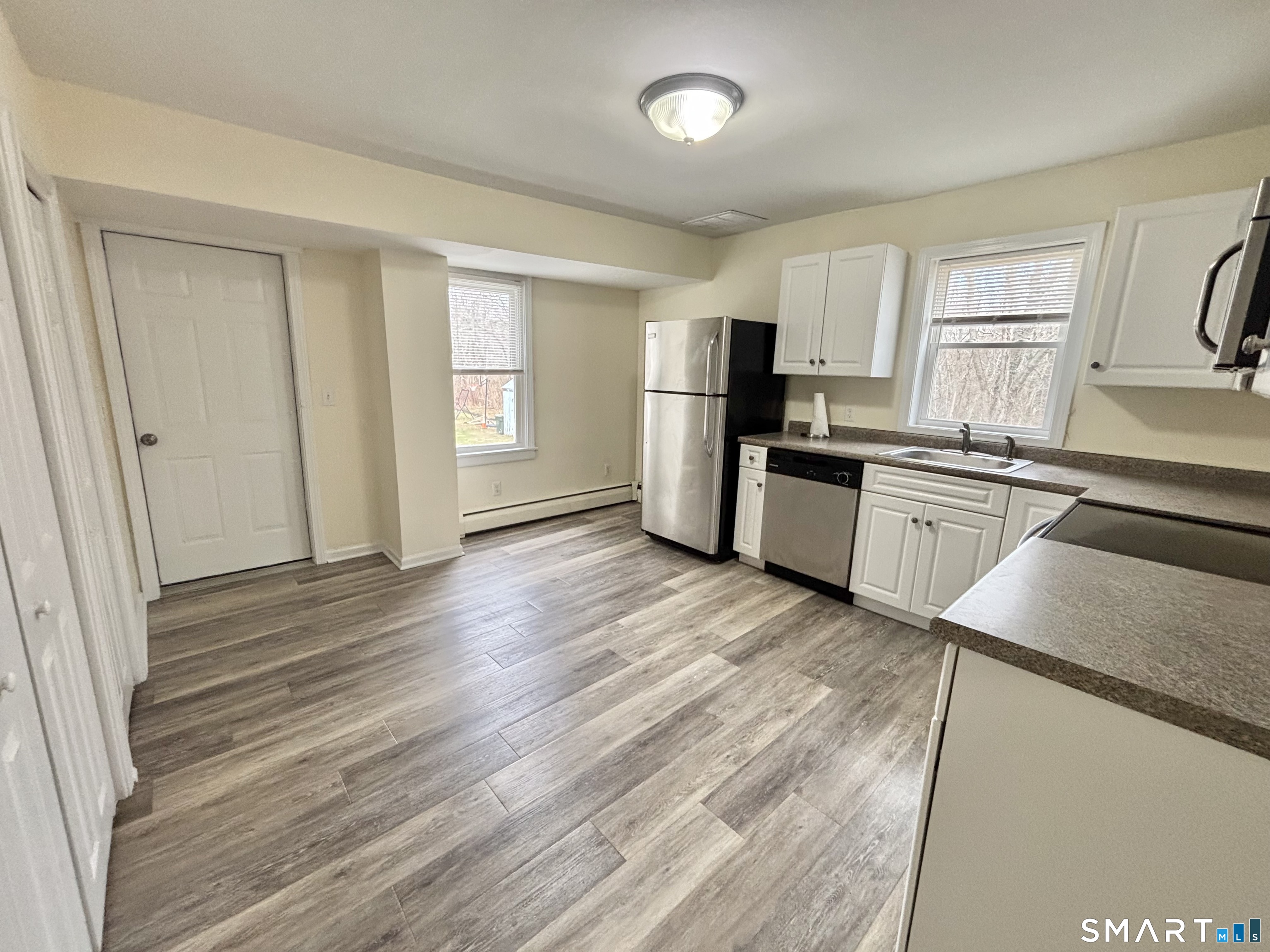 61 Scotland Avenue, Unit NORTH Madison, CT 06443 - Photo 4 of 19 a kitchen with granite countertop wooden floors and stainless steel appliances