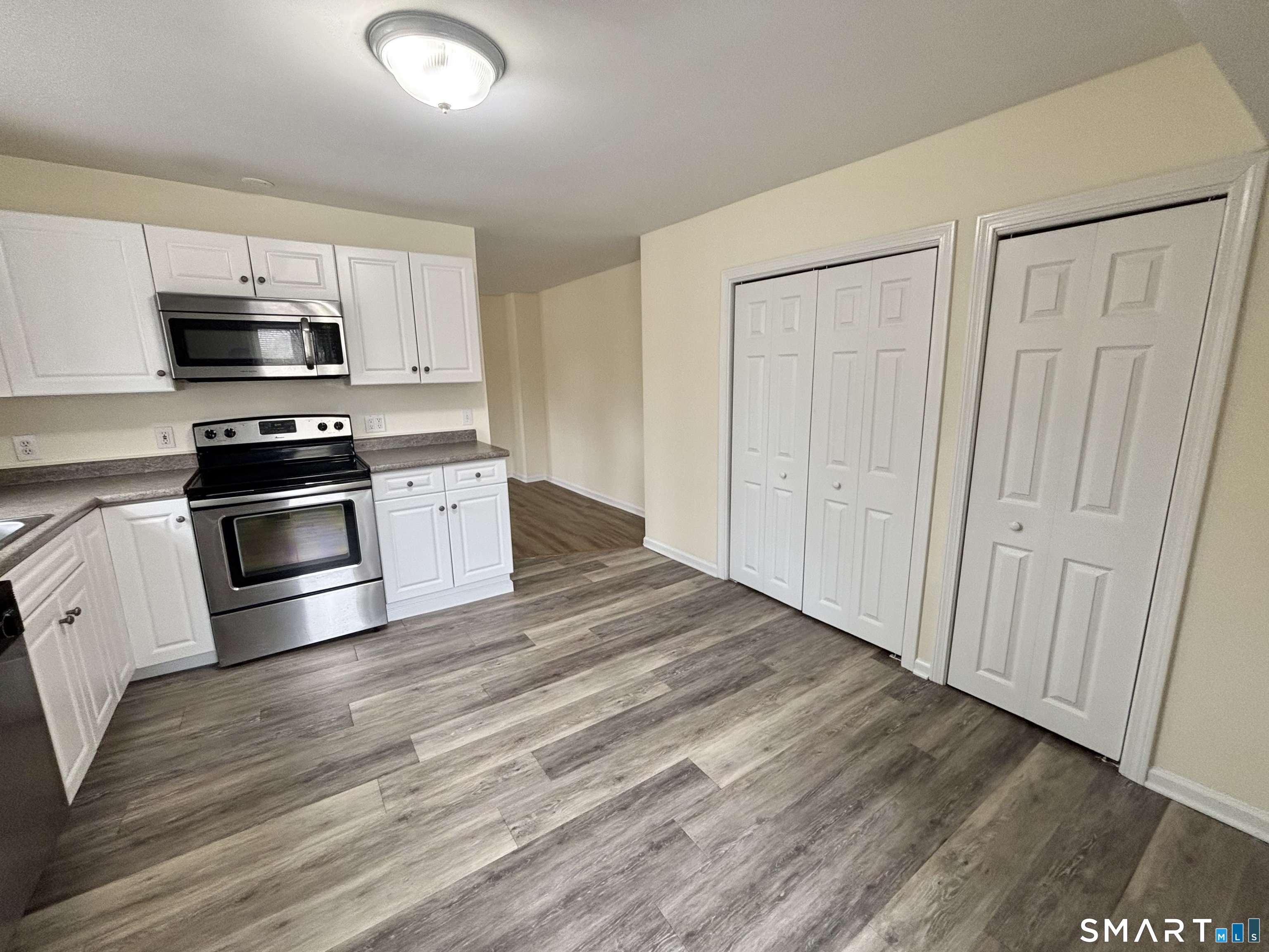 61 Scotland Avenue, Unit NORTH Madison, CT 06443 - Photo 6 of 19 a kitchen with stainless steel appliances and white cabinets