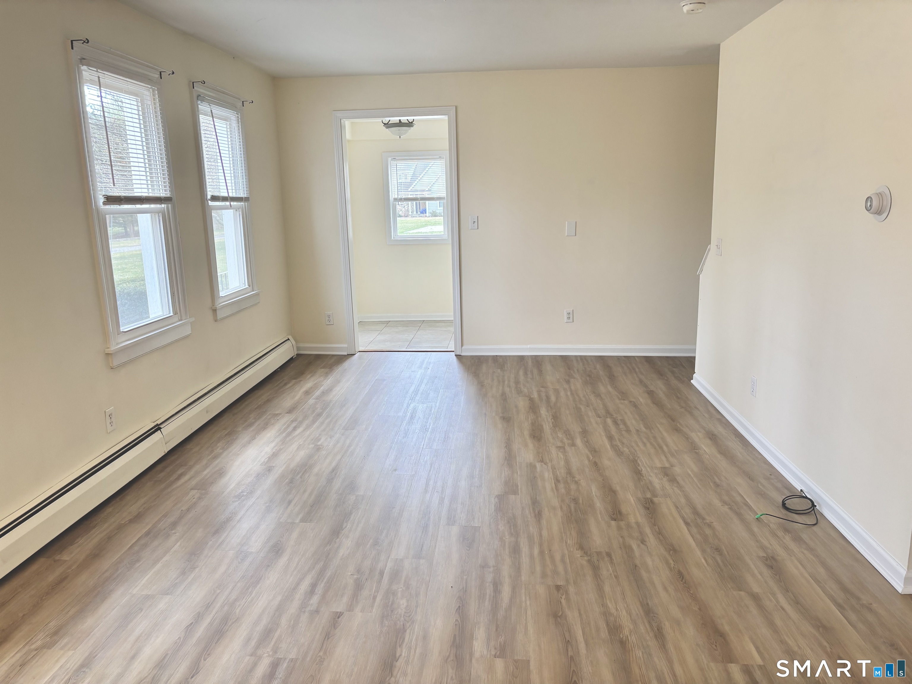 61 Scotland Avenue, Unit NORTH Madison, CT 06443 - Photo 8 of 19 an empty room with wooden floor and windows