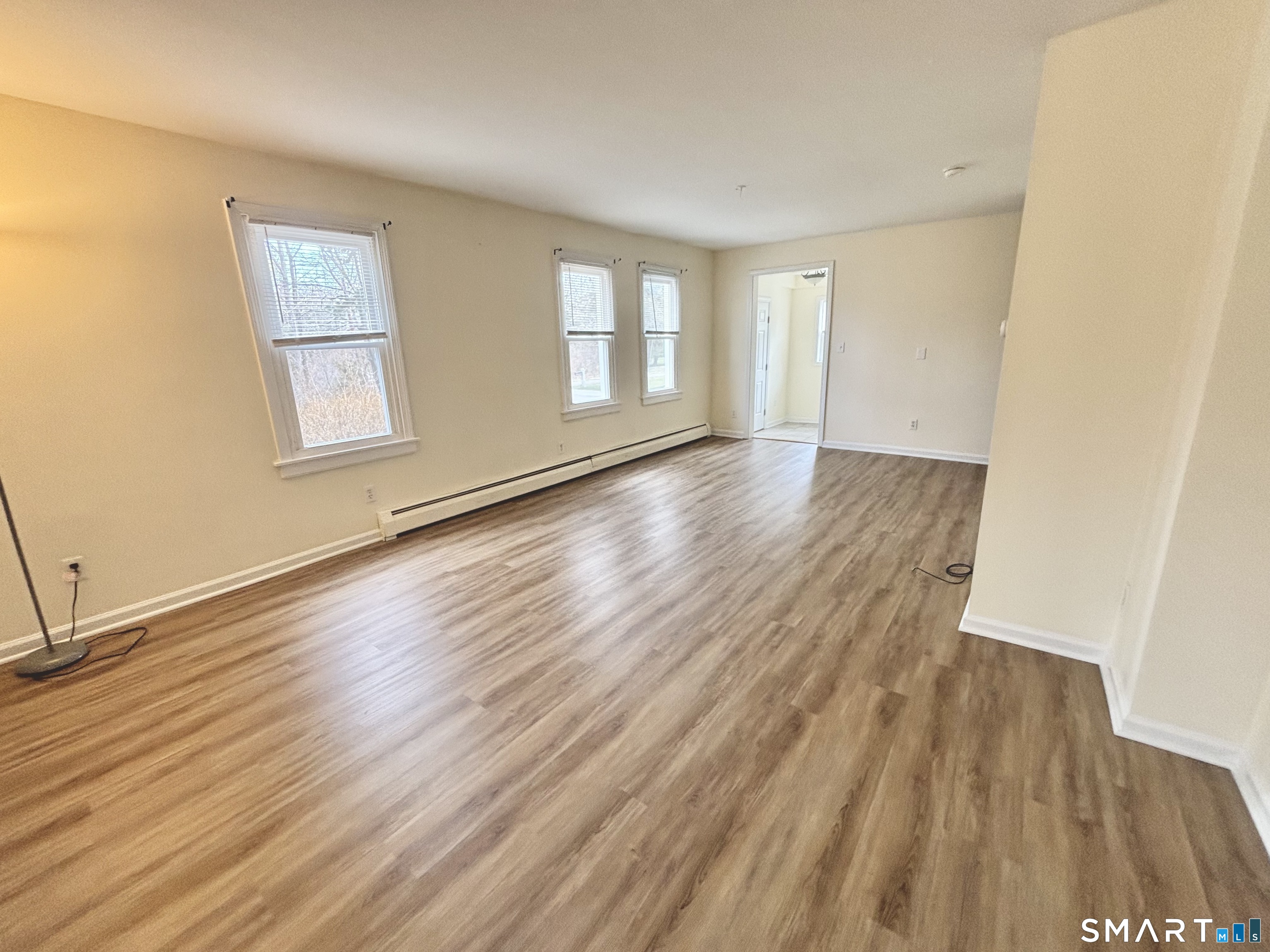 61 Scotland Avenue, Unit NORTH Madison, CT 06443 - Photo 10 of 19 a view of an empty room with wooden floor and a window