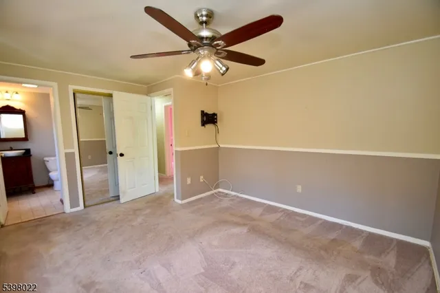 an empty room with closet and a ceiling fan
