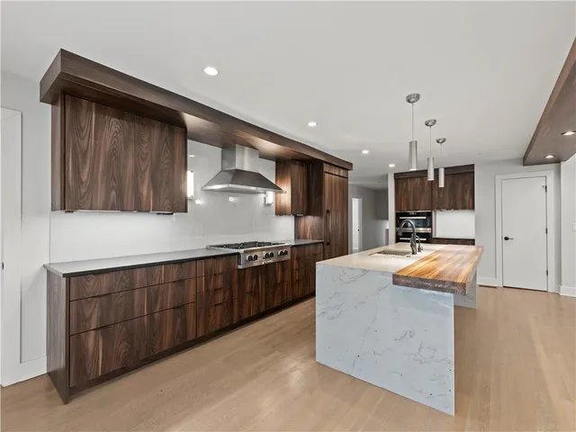 a kitchen with stainless steel appliances granite countertop wooden cabinets and granite counter tops
