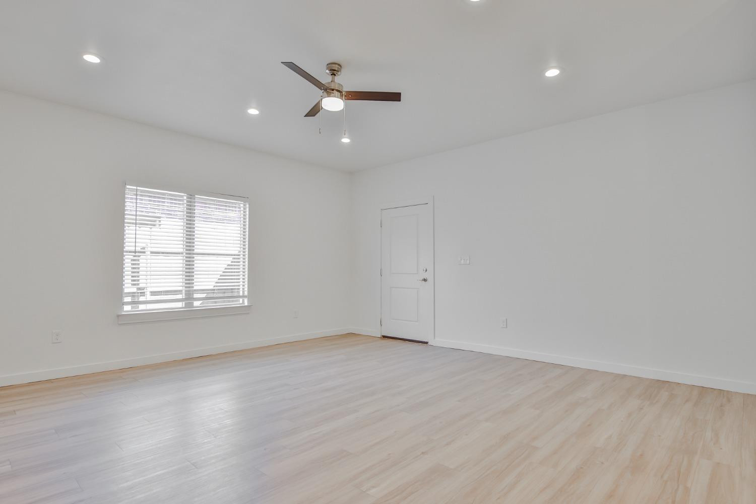 5508 Itasca Street Lubbock, TX 79416 - Photo 4 of 25 an empty room with wooden floor fan and windows
