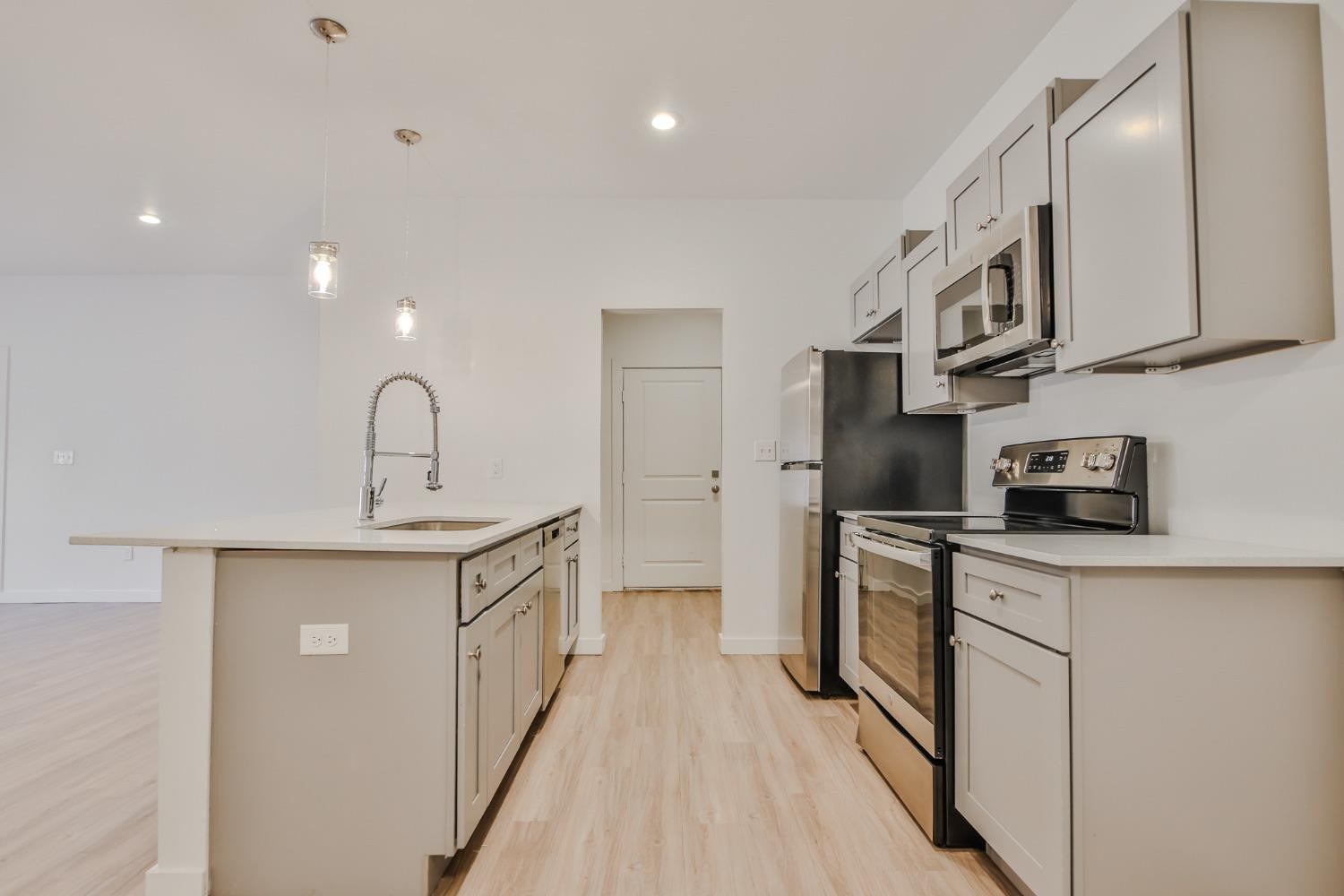 5508 Itasca Street Lubbock, TX 79416 - Photo 7 of 25 a kitchen with stainless steel appliances granite countertop a sink a stove a refrigerator and white cabinets
