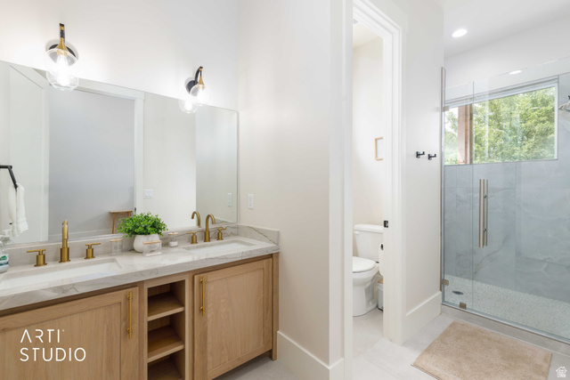 1188 South Old Trappers Loop Road Huntsville, UT 84317 - Photo 37 of 92 Dual vanity with gold-finish faucets and light wood-finish cabinetry, set against a full-width mirror