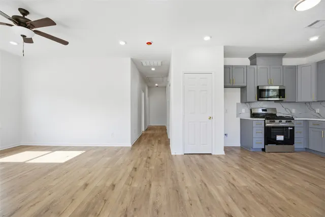 a view of kitchen with stainless steel appliances refrigerator stove microwave and cabinets