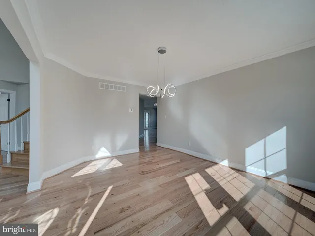 a view of a hallway with wooden floor and entryway