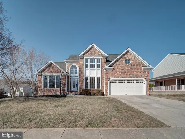 a view of a house with a yard and large trees
