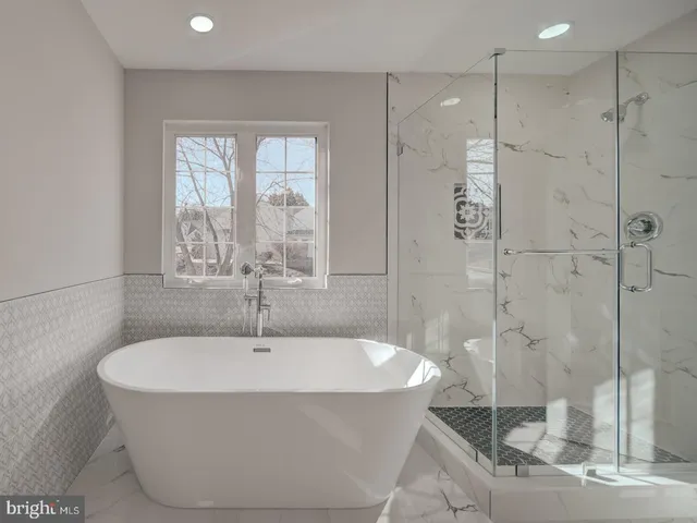 an empty room with wooden floor fireplace and windows