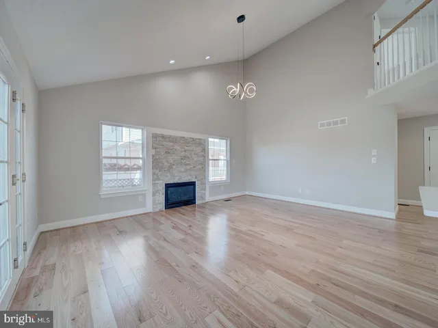 a view of an empty room with wooden floor and entryway