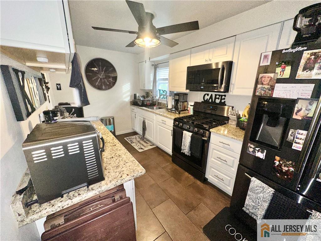 15 Halstead Road New Brunswick, NJ 08901 - Photo 12 of 45 a kitchen with stainless steel appliances a stove a microwave a refrigerator and a sink