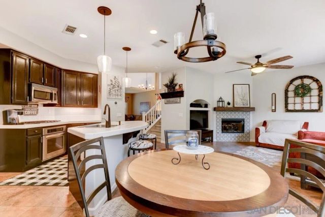 a room with stainless steel appliances kitchen island a table and chairs in it