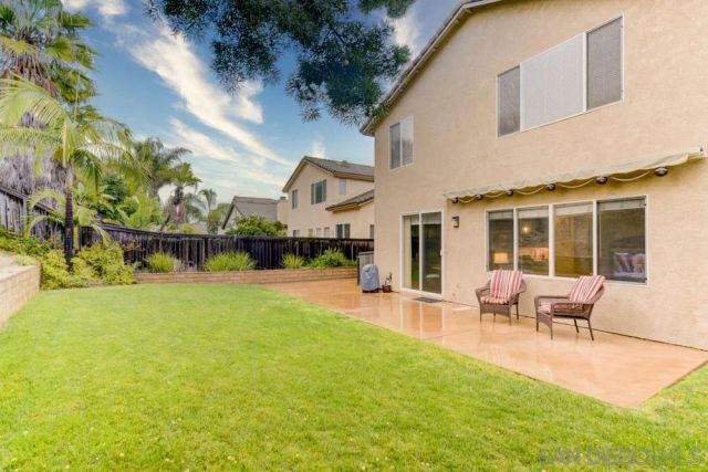 a backyard of a house with table and chairs