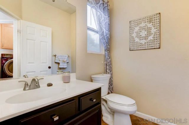 a bathroom with a sink a toilet and a mirror