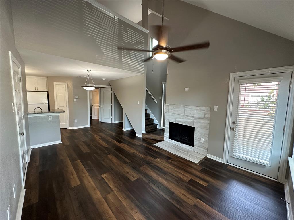 9819 Walnut Street, Unit 206 Dallas, TX 75243 - Photo 1 of 1 a view of a livingroom with wooden floor a ceiling fan and staircase