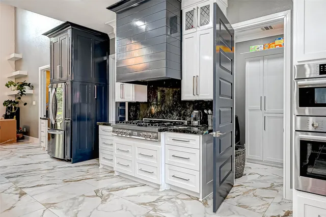 a kitchen with stainless steel appliances granite countertop a refrigerator and a stove