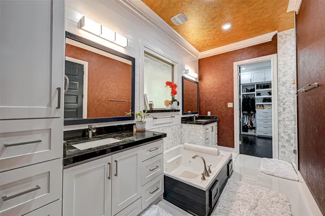 a bathroom with a double vanity sink a mirror and a bathtub