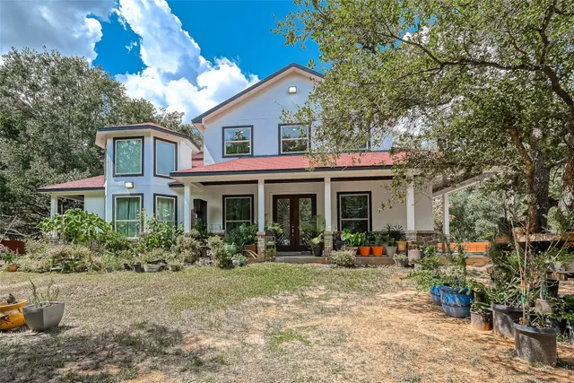 a front view of a house with lots of trees around