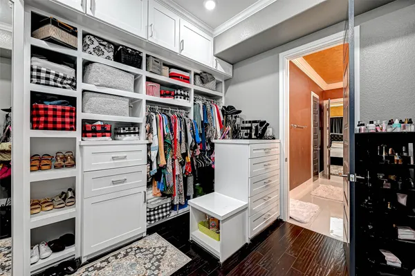 a view of walk in closet with clothes and shoes