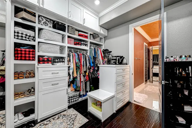 a view of walk in closet with clothes and shoes