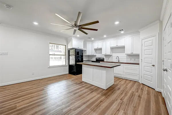 a kitchen with stainless steel appliances a refrigerator and wooden floor