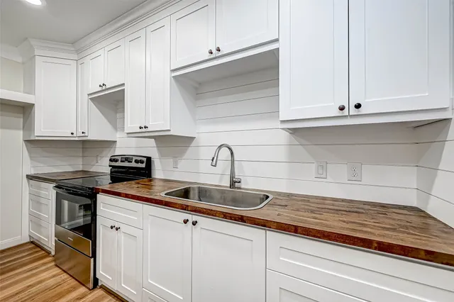 a kitchen with granite countertop white cabinets and a sink