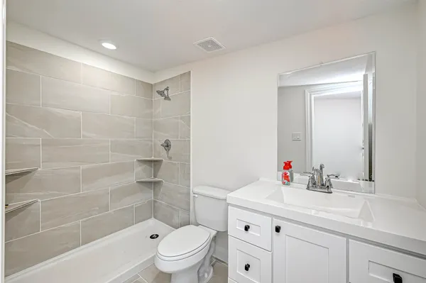 a bathroom with a sink a toilet and shower