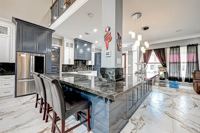 a kitchen with stainless steel appliances kitchen island granite countertop a table chairs in it and wooden floors
