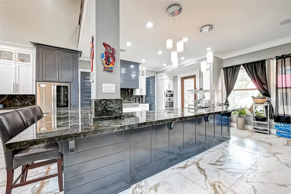 a kitchen with stainless steel appliances kitchen island granite countertop a stove and cabinets