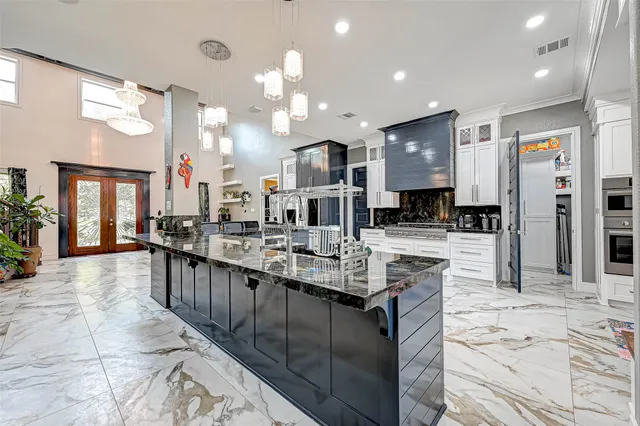 a large kitchen with kitchen island a sink appliances and cabinets