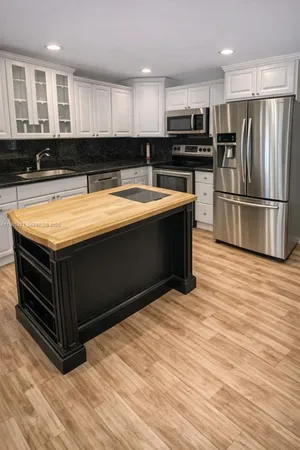 a kitchen with stainless steel appliances granite countertop a sink and a stove