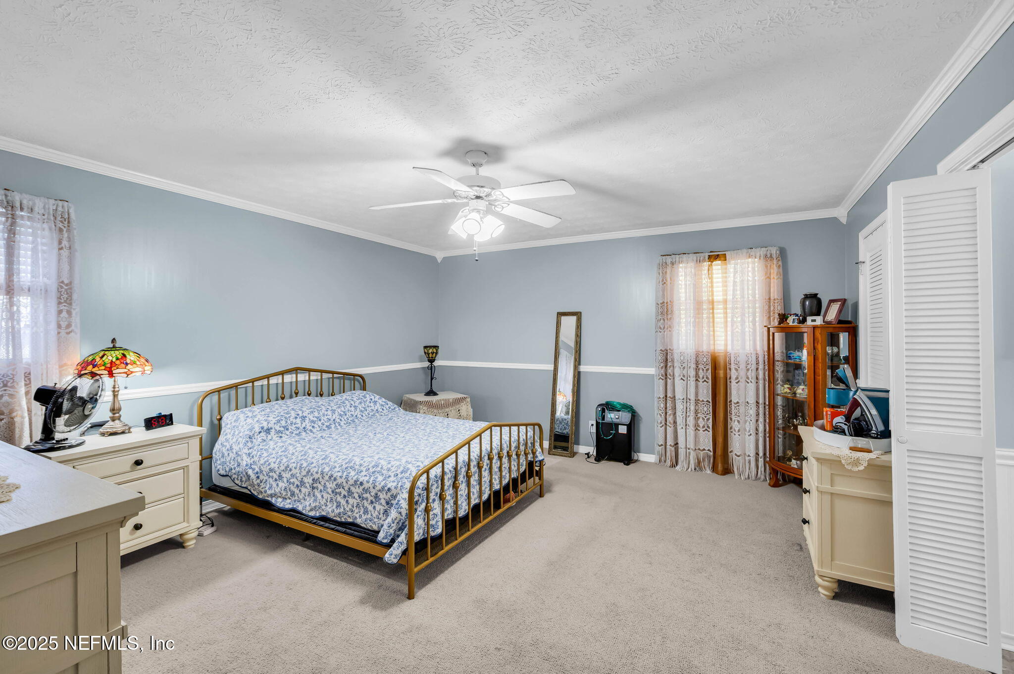 5495 Forrest Drive Orange Park, FL 32073 - Photo 20 of 34 a bedroom with a bed and a chandelier