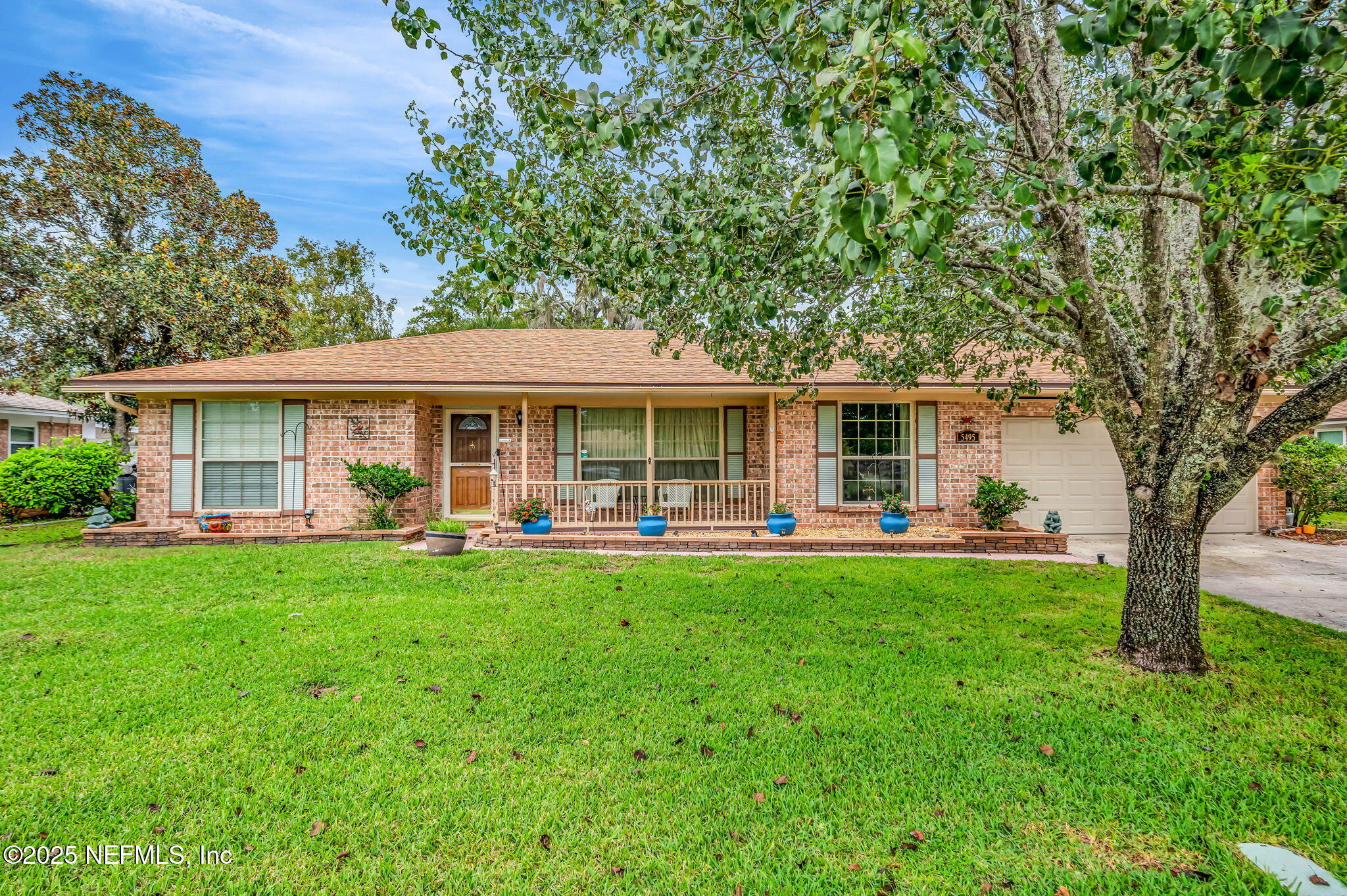 5495 Forrest Drive Orange Park, FL 32073 - Photo 2 of 34 a front view of a house with swimming pool and porch with table and chairs