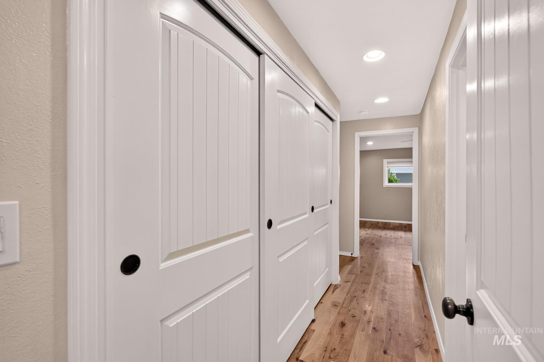 9622 Delaware Street Boise, ID 83709 - Photo 19 of 48 Hallway featuring wood-finish flooring, recessed lighting, and white paneled doors with black hardware