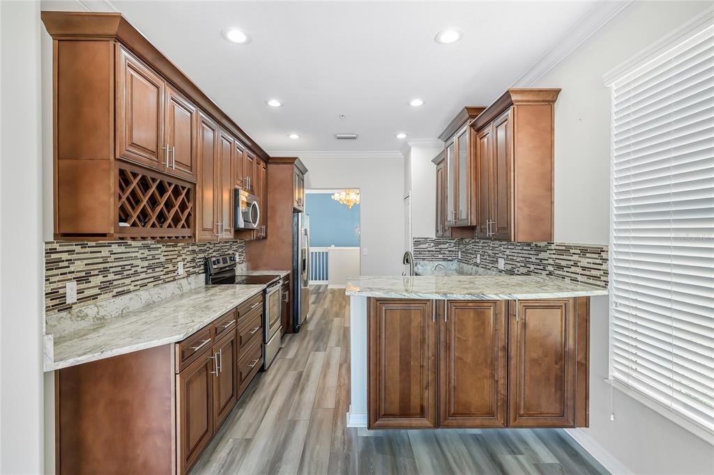 5677 Fossano Drive, Unit 506 Sarasota, FL 34238 - Photo 11 of 44 a kitchen with stainless steel appliances granite countertop a stove and a sink