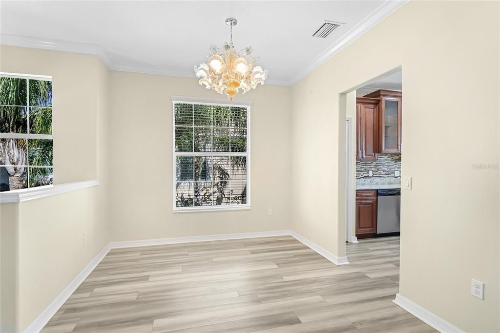 5677 Fossano Drive, Unit 506 Sarasota, FL 34238 - Photo 13 of 44 a view of an empty room with wooden floor and windows