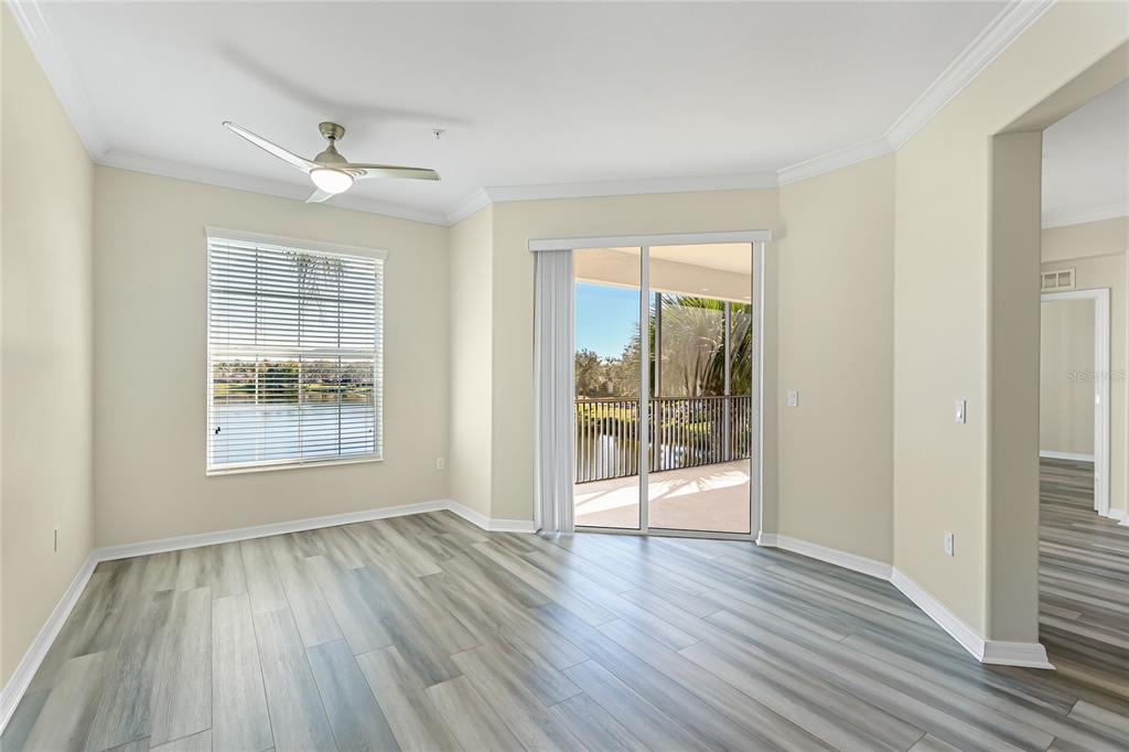 5677 Fossano Drive, Unit 506 Sarasota, FL 34238 - Photo 14 of 44 a view of an empty room with wooden floor and a window