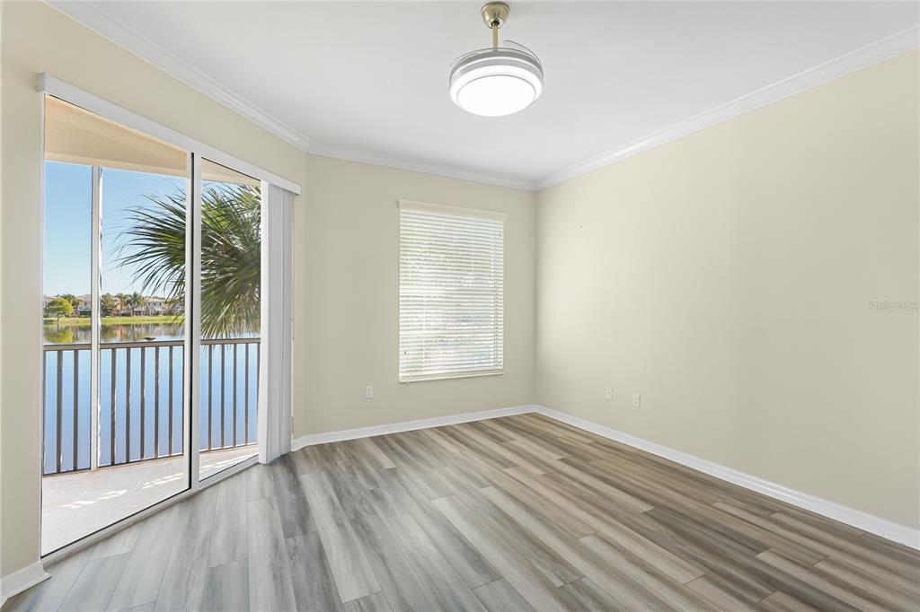5677 Fossano Drive, Unit 506 Sarasota, FL 34238 - Photo 15 of 44 an empty room with wooden floor and windows